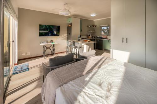 a bedroom with a large bed and a kitchen at Port Owen Marina by First Private Stays in Velddrif