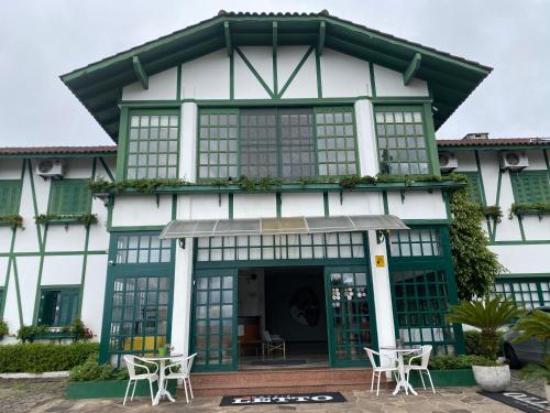 a building with chairs and tables in front of it at Letto Hotel Candeeiro da Serra in Salvador do Sul
