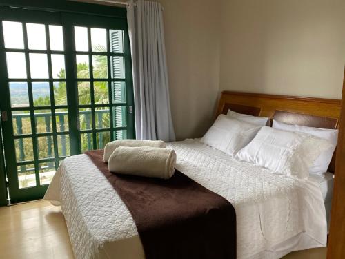 a bedroom with a bed with a large window at Letto Hotel Candeeiro da Serra in São Salvador