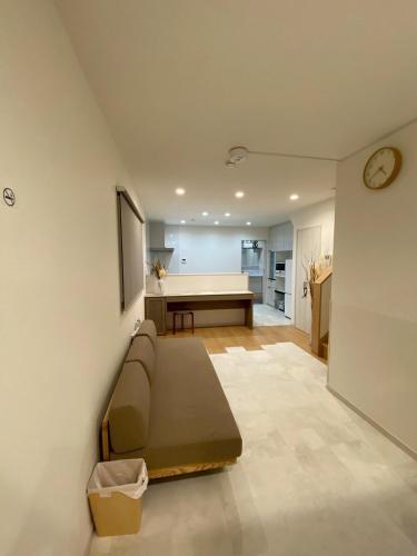 a living room with a couch and a table at 一軒家貸切尾道観光 JR松永駅徒歩1分MAX6人 Cozy Entire House Great for Onomichi Sightseeing! 1-Min Walk from JR Matsunaga Station, Free Parking, Sleeps up to 6 Guests in Fukuyama