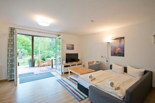 een slaapkamer met een bed en een woonkamer bij Müritzparadies - Feriendorf Alte Fahrt in Rechlin