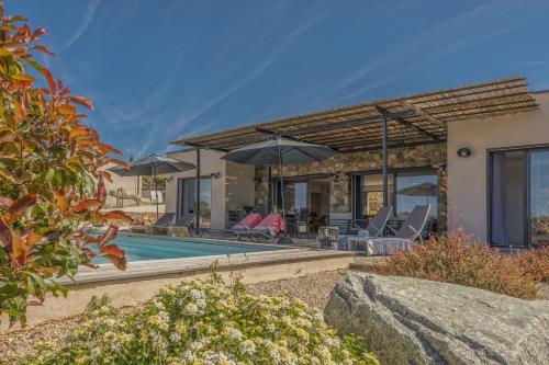 a house with a swimming pool with umbrellas at Villa Davia in Corbara