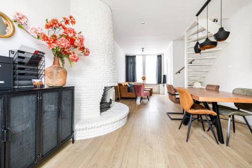 a living room with a table and a fireplace at The Alkmaar Family House in Alkmaar