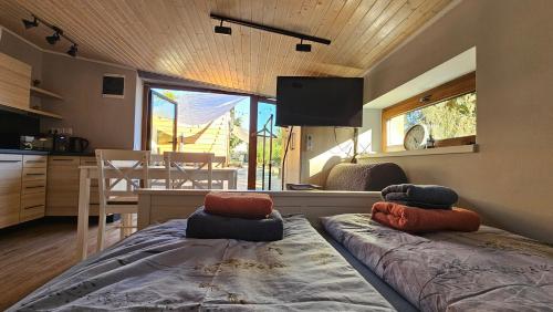 a room with two beds in a room with a kitchen at G24 Woodhouse in Kaposvár