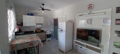 a kitchen with a refrigerator and a table in it at Linda Casa de Praia com Piscina em Itapoá in Itapoa