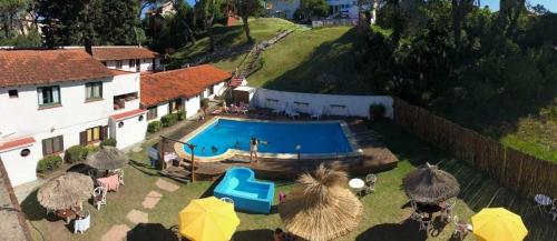 eine Draufsicht auf einen Swimmingpool mit Sonnenschirmen in der Unterkunft Chill hotel in Villa Gesell