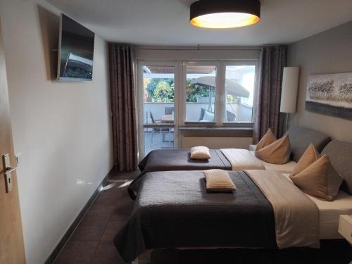 Dos camas en una habitación de hotel con ventana. en Tango apartment, en Breitenworbis