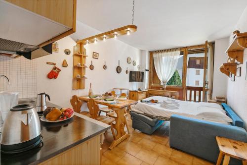 Il comprend une cuisine et un salon avec un lit et une table. dans l'établissement Studio Valleverde 11D Ski In Ski Out - Happy Rentals, à Borgata Sestriere