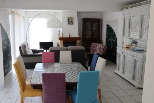a living room with a table and chairs at Vacances chez Cali - Maison 10 pers in La Séguinière