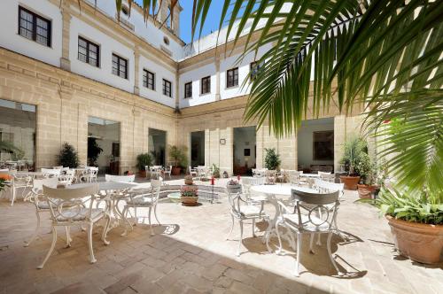 a courtyard with tables and chairs in a building at Crisol Monasterio de San Miguel in El Puerto de Santa María