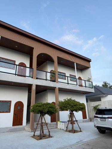 a building with two trees in front of it at Minimal Apartment in Central of city Near Central 1 km in Nakhon Pathom