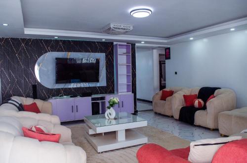a living room with couches and a flat screen tv at Daisy Apptment in Malindi