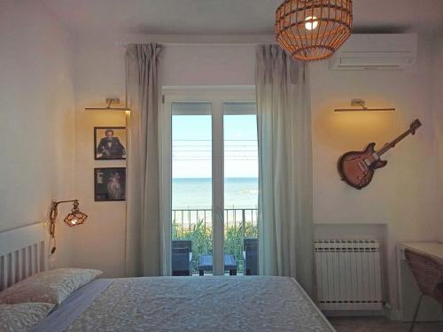 a bedroom with a guitar on the wall next to a window at Colombo 477 Stanze Jazz, Soul, Classica in Civitanova Marche