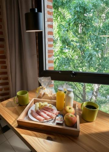 een dienblad met eten op een houten tafel met fruit en sap bij H5063 in Buenos Aires