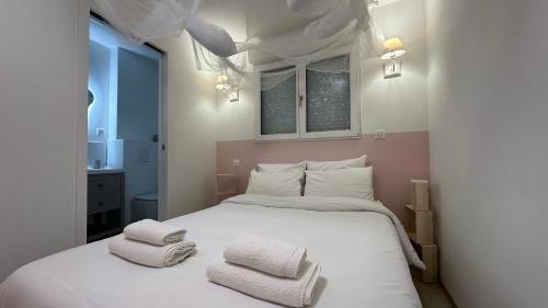 a bedroom with a white bed with two towels on it at Le petit Cocon in Nevers