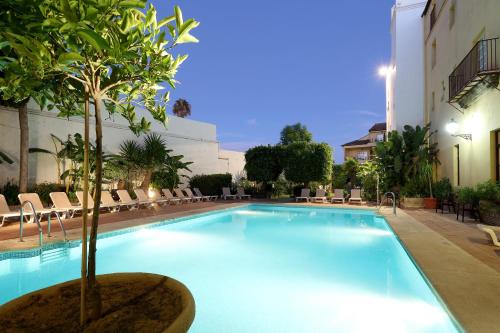 a swimming pool with a tree in the middle at Crisol Monasterio de San Miguel in El Puerto de Santa María