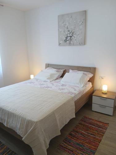 a bedroom with a bed and a picture on the wall at Apartman Lasko in Razvala