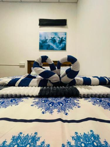 a bedroom with a bed with a blue and white blanket at Villa Turtle in Galle
