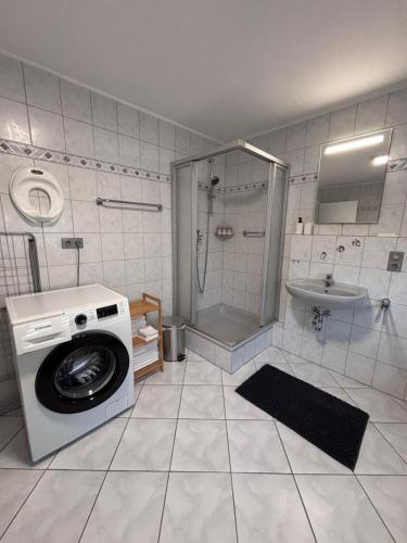 a washing machine in a bathroom with a shower at Familienfreundliche Ferienwohnung an der Antoniuslinde im Kurort in Erwitte