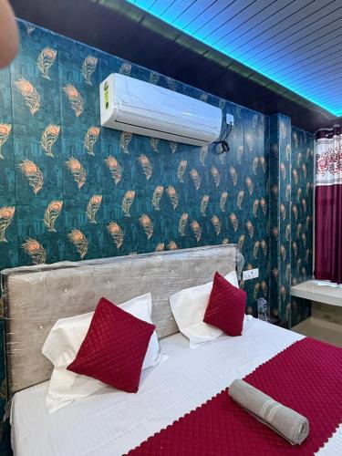 ein Schlafzimmer mit einem Bett mit roten Kissen und einer Heizung in der Unterkunft The Yash Residency in Ayodhya