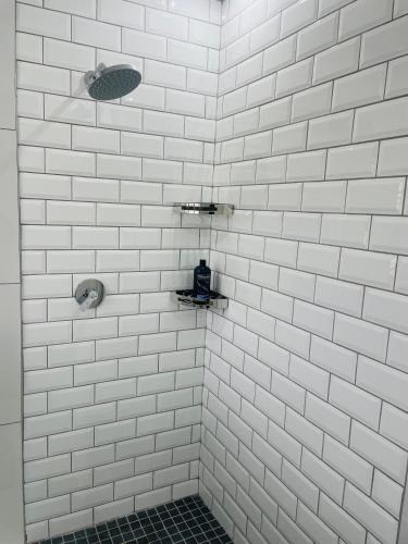 a white tiled shower with white tiles on the wall at 10 on Frangipani in Richards Bay