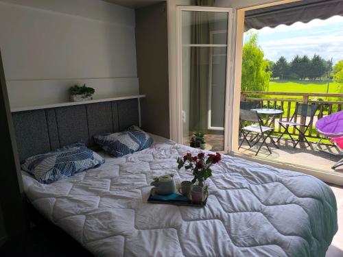 une chambre avec un lit décoré de fleurs et un balcon dans l'établissement Gîte Le 47, à Levernois