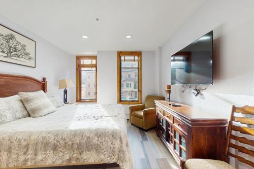 a bedroom with a bed and a flat screen tv at Main Street Station #2302 in Breckenridge