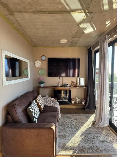 a living room with a couch and a flat screen tv at Victoria Ocean View Room in Ponta do Pargo