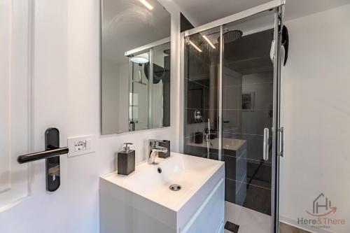 a white bathroom with a sink and a shower at Historic Palace Duplex - Cruises 2min - AC - WiFi in Savona