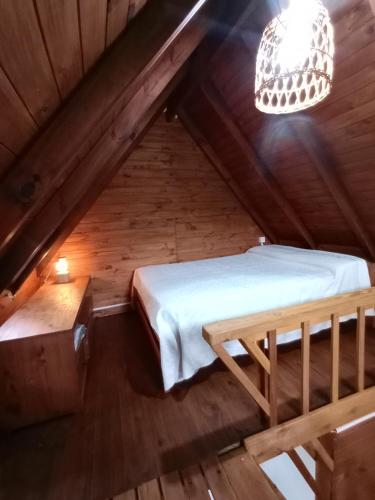 ティグレにあるTinyHouseLosAndesのベッドとシャンデリア付きの屋根裏部屋