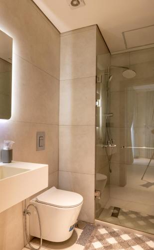a bathroom with a toilet and a sink and a shower at Swiss Lodge, Labone in Accra