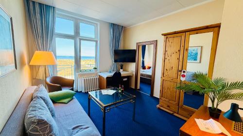 a living room with a couch and a table at "Sanddorn", Kur- und Ferienhotel, Direkte Strandlage, Fahrstuhl in Warnemünde