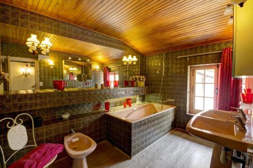 a bathroom with a tub and a toilet and a sink at Gîte Des Roties in Poncins