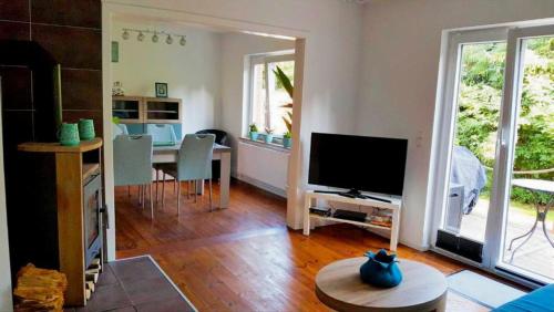 ein Wohnzimmer mit Fernseher und Tisch mit Stühlen in der Unterkunft Martha in Sahrensdorf