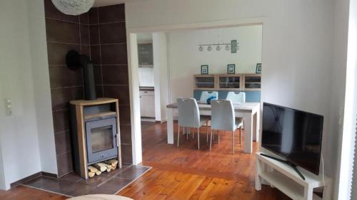 ein Wohnzimmer mit einem Kamin und einem Tisch mit Stühlen in der Unterkunft Martha in Sahrensdorf