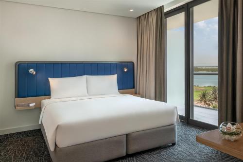 a bedroom with a large bed and a large window at Yas Plaza Bay by IHG in Abu Dhabi