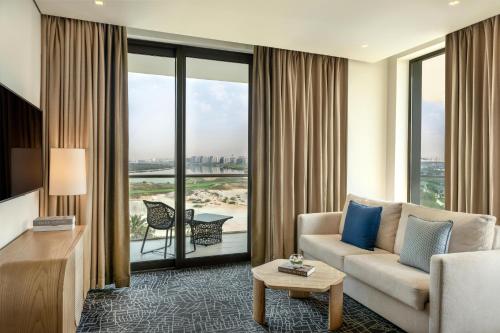 a living room with a couch and a large window at Yas Plaza Bay by IHG in Abu Dhabi