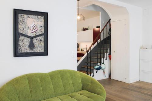 a green couch in a living room with a staircase at Ideal stay in Puteaux with private courtyard in Puteaux