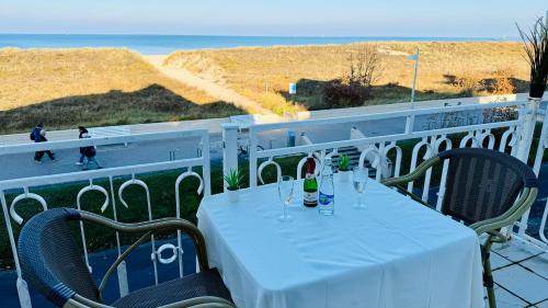 a table with wine glasses on a balcony with the beach at "Sanddorn", Kur- und Ferienhotel, Direkte Strandlage, Fahrstuhl in Warnemünde