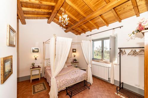 a bedroom with a canopy bed and a window at Agriturismo Specchio Del Lago in Montefiascone