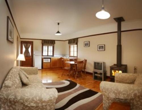 sala de estar con sofá, sillas y chimenea en Cypress Ridge Cottages, en Ballandean