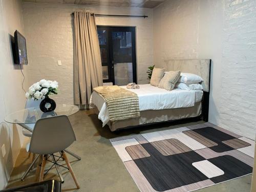 a bedroom with a bed and a glass table at Serenity sleep in Johannesburg