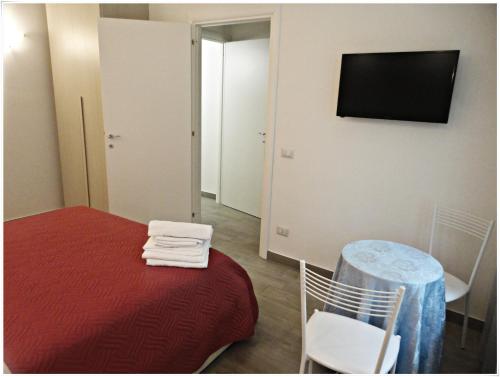 a room with a bed and a table and a television at LunaBlù in Rome
