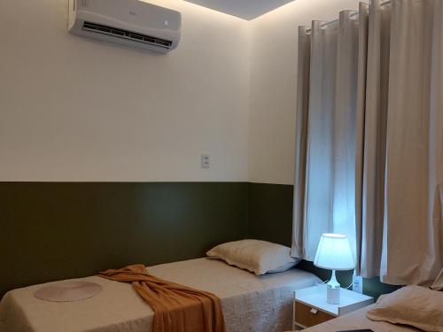 a bedroom with two twin beds and a window at Studio 101 Cop 30 in Belém