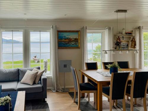 ein Wohnzimmer mit Tisch und Couch in der Unterkunft Coastal Cabin In Kastneshamn in Brostadbotn