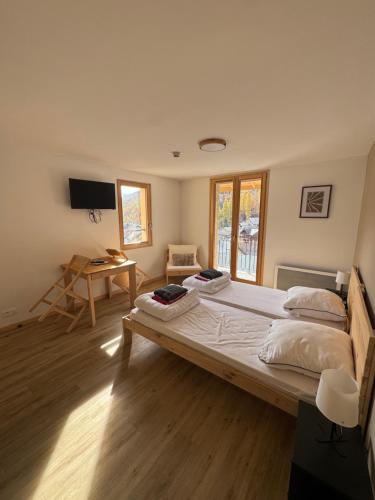 een slaapkamer met een groot bed en een bureau bij Résidence le Prorel - Serre chevalier in Saint-Chaffrey