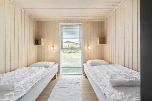 two beds in a room with a window at 8424-Knebel-Rastestedet-46 in Knebel
