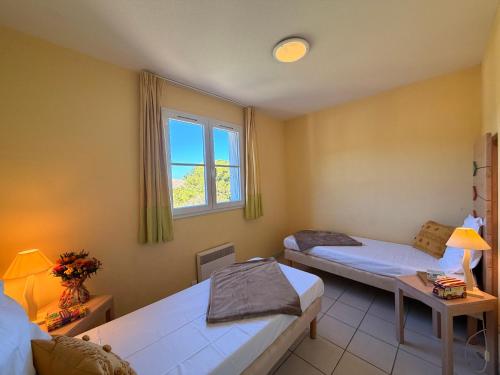 En eller flere senge i et værelse på Lagrange Grand Bleu Vacances – Résidence Le Village des Aloès