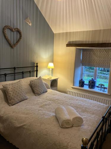 a bedroom with a bed with two towels on it at Miners Cottage in Bakewell