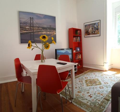 a dining room with a white table and red chairs at Stay Home Lisbon in Lisbon